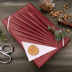 a pair of scissors sitting on top of red envelopes next to some paper and nuts