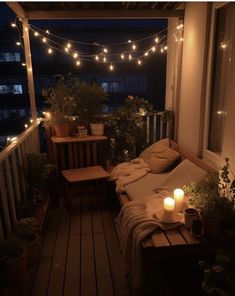 a porch with lights strung over it and some plants on the balcony table next to the couch