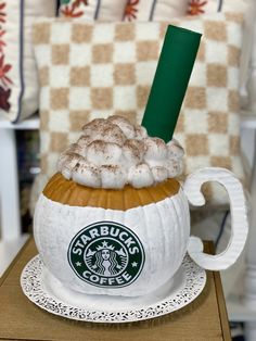 there is a starbucks drink in a pumpkin mug