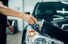 a man waxing the hood of a black car