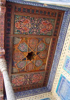 an intricately decorated ceiling in the middle of a room with blue and red tiles