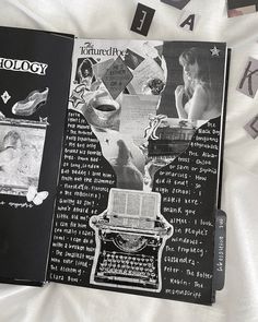 an open book sitting on top of a bed covered in letters and photos next to a typewriter