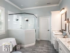 a large bathroom with two sinks and a bathtub in the middle of the room