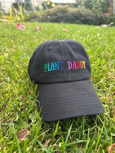 Unveiling the vibrant and chic Plant Daddy hat with colorful letters on a sleek black base, brought to you by Plant Scouts – your ultimate destination for all things plant-related. Beyond being a practical accessory shielding you from the sun as you nurture your indoor haven, this hat is a delightful testament to your affection and commitment to your cherished plants. The lively "Plant Daddy" text adds a touch of playfulness, bringing joy to your moments and broadcasting your green-thumb pride t Multicolor Curved Brim Hat With Letter Print, Fun Black Hat For Outdoor, Black Dad Hat With Curved Brim As Gift, Fun Black Outdoor Hat, Fun Black Outdoor Hats, Fun Black Baseball Cap For Outdoor, Black Hat With Letter Print And Curved Visor, Fun Black Baseball Cap With Letter Print, Father's Day Black Curved Brim Snapback Hat