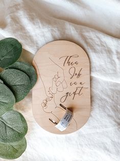 a wooden plaque with the words, this is a gift on it next to some green leaves