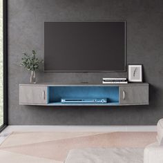 an entertainment center with a flat screen tv mounted on it's side, in front of a large window