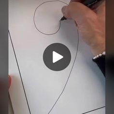 someone is drawing something on paper with a marker