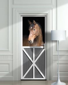 an open door with a horse in the stable on it's side and a lamp next to it