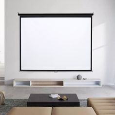 a living room with couches and a large screen on the wall in front of it