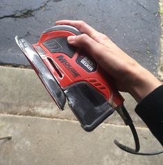 a person holding a cordless drill in their right hand and an electric tool in the other hand