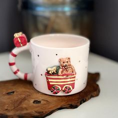 a coffee cup with a teddy bear riding in a train on it's side