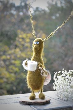 a stuffed animal holding a frisbee on top of a table next to flowers