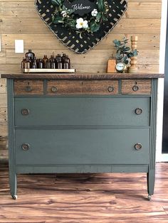 an old dresser is painted green and has a heart shaped sign above it that says welcome