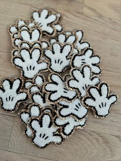 several mickey mouse patches sitting on top of a wooden table with white and black designs