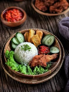 a wooden bowl filled with rice, cucumbers and other foods on top of a table