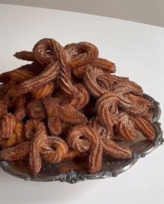 a glass bowl filled with cinnamon twists on top of a table