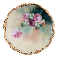 a plate with pink flowers painted on the side and gold trimming around the edge