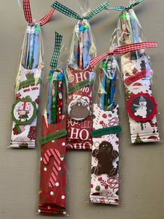 six wrapped christmas gifts in cellophane bags with ribbons and tags on them, sitting on a table