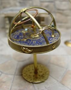 an antique brass and blue clock on a stand