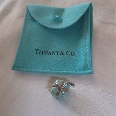 Tiffany & Co. Blue Box Charm Is An Icon! The Charm Is Tiffany Blue Enamel Over Sterling Silver With A Bow In Sterling Silver. This Can Be Worn As A Pendant Or Added To A Charm Bracelet. This Piece Is 3/4 Inch Square. It Is Stamped On The Bottom T & Co. 925. Comes With Blue Tiffany Pouch As Pictured. It Is In Very Good Pre-Owned Condition, The Silver Bow Could Use A Polish. This Is A Current Style. Tiffany Gifts, Buy List, Silver Bow, Current Styles, Blue Box, Tiffany Blue, Tiffany & Co., Blue And Silver, Womens Jewelry Necklace