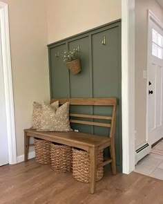 a wooden bench sitting in the middle of a hallway next to a door with baskets on it