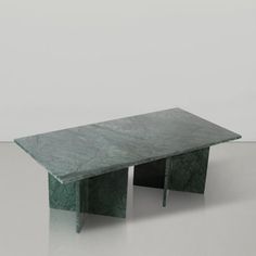 a green table sitting on top of a white floor