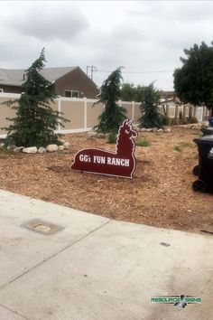 a sign that reads 664 fun ranch in front of some trees and trash cans