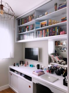 a room with a desk, bookshelf and television on the wall in it