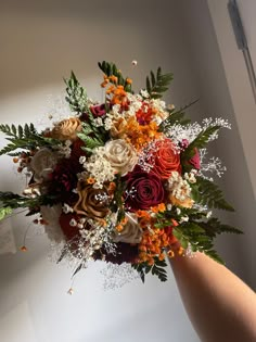 a person holding a bouquet of flowers in their hand