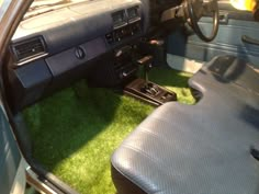 the interior of an old car with artificial grass on the floor and dash board area