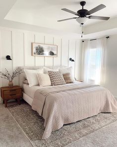 a bedroom with a bed, dresser and ceiling fan