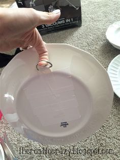 a person holding a white plate on top of a table