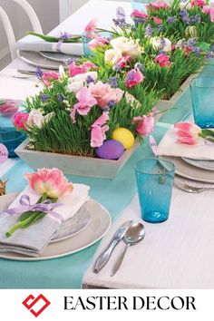 an easter table setting with flowers and napkins on the place settings, including blue glassware