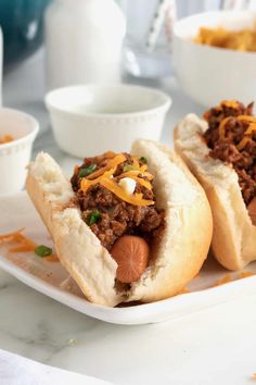 two chili cheese dogs are on a plate