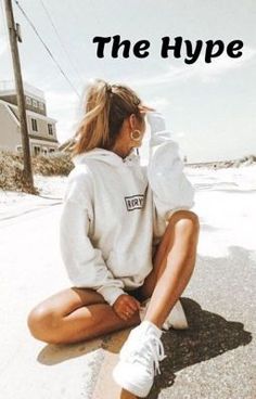 a woman sitting on the ground wearing white sneakers