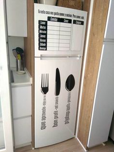 a white refrigerator freezer sitting inside of a kitchen next to a wooden cabinet filled with utensils