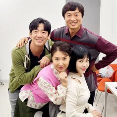 three people are posing for a photo together in front of a computer desk and chair