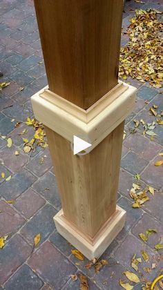 a wooden post on the ground with leaves around it