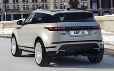 a silver range rover driving down a city street