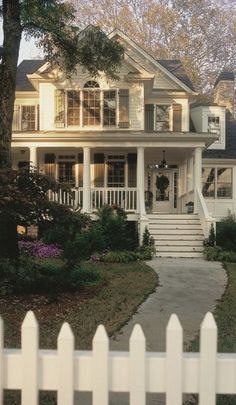 a white house with porch and stairs leading to the front door