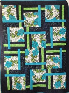 a blue and green quilt with flowers on the front, along with black backings