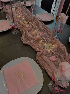 the table is set with pink napkins and place settings for an elegant dinner party