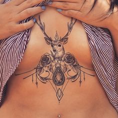 a close up of a person's stomach with tattoos on it and an antelope