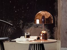 a table with a lamp on it next to a chair