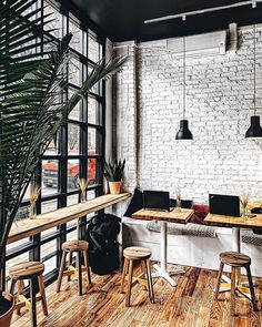 an office with white brick walls and wooden floors