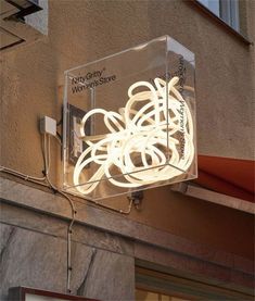 a light fixture on the side of a building that is lit up with white lights