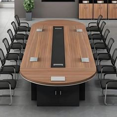 a large conference table with chairs around it in an empty office space, next to a plant