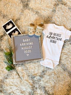 a baby's first birthday outfit and shoes are on the ground next to a sign