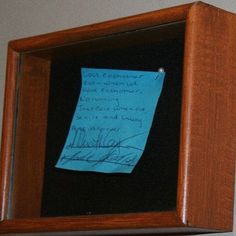 a piece of blue paper taped to a wooden frame with writing on the inside and outside