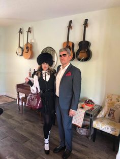 a man and woman standing next to each other in front of guitars